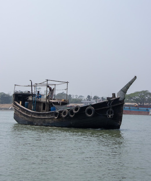 Schöne Holz-Trawler auf dem Fluss Closeup erschossen Hölzernes Fischerboot, das durch einen Fluss geht Schöne südostasiatische Natur mit einem Wasserfahrzeug und blauem Himmel Trawler, der durch die Wasserstraße geht