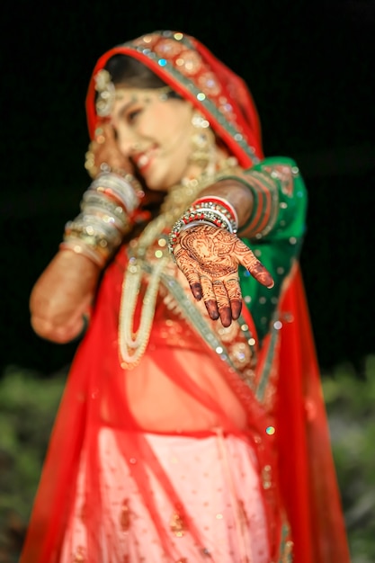 Schöne indische Braut mit Sari und goldenem Schmuck bei indischer Hochzeit