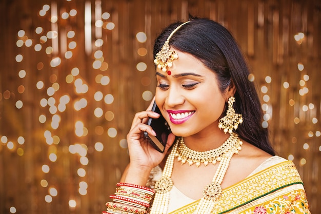 Schöne indische Frau in traditioneller Kleidung, die am Telefon spricht