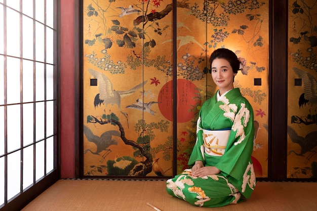 Foto schöne japanerin in einem grünen kimono