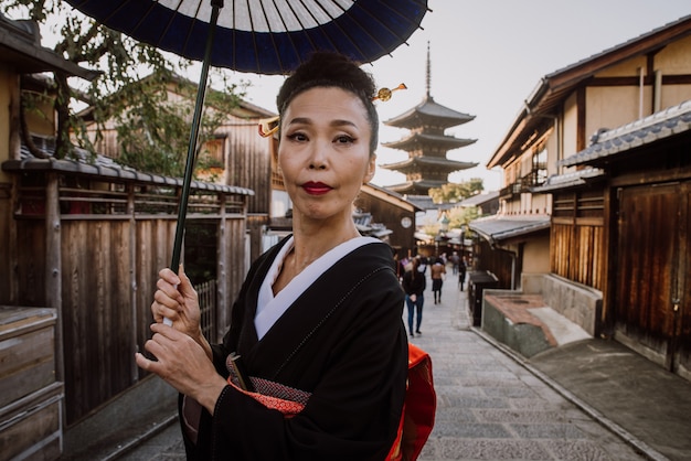 Schöne japanische ältere Frau, die im Dorf geht. Typischer traditioneller japanischer Lebensstil