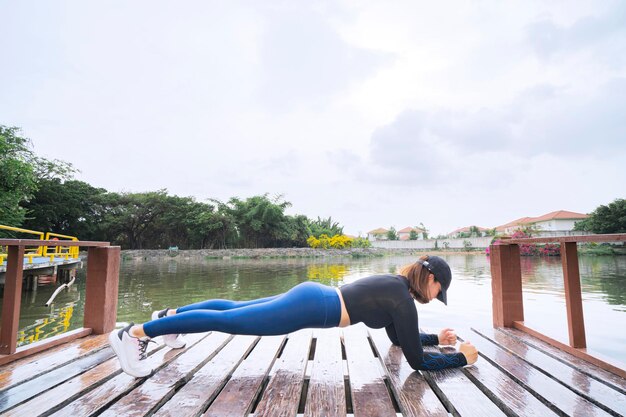 Foto schöne joggerin, die während des morgendlichen trainings im park trainiert