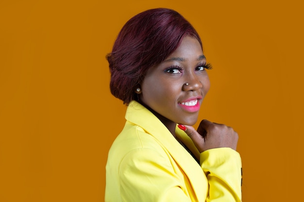 Schöne junge afrikanische Frau in einer gelben Jacke mit Make-up