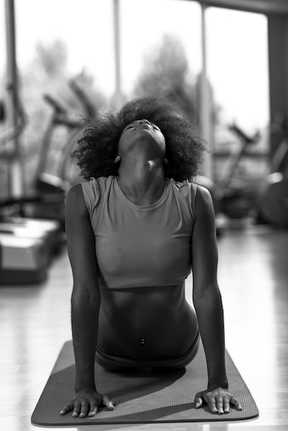schöne junge Afroamerikanerin übt Yoga im Fitnessstudio aus