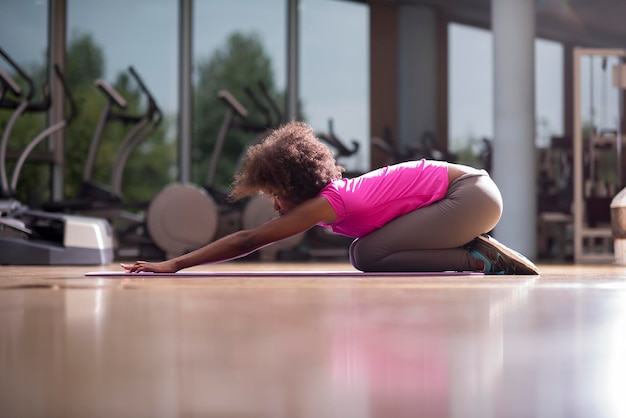 schöne junge Afroamerikanerin übt Yoga im Fitnessstudio aus