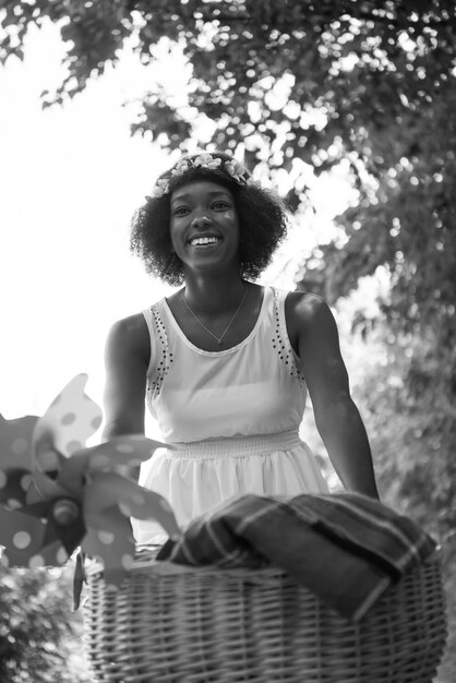 Foto schöne junge afroamerikanische frauen genießen es, an einem sonnigen sommertag fahrrad im wald zu fahren