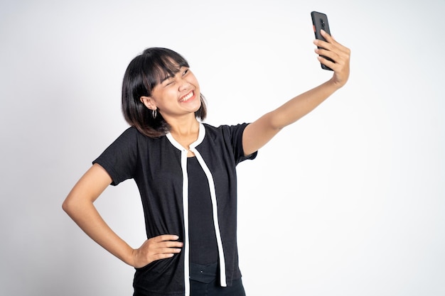 Schöne junge Asiatin macht Selfie-Portrait mit Smartphone