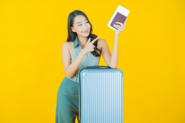 Schöne junge asiatische Frau des Porträts mit Gepäcktasche und Reisepass bereit für die Reise