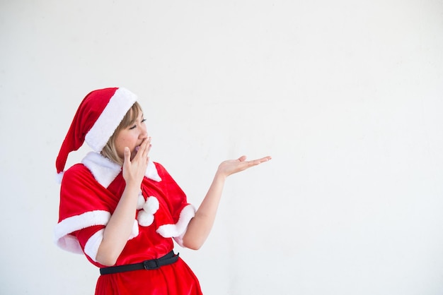 Schöne junge asiatische Frau in Weihnachtsmann-Kleidung auf weißem HintergrundThailänderGesendetes Glück für KinderFrohe WeihnachtenWillkommen im WinterHappy Woman-Konzept