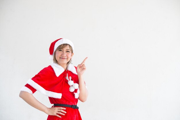 Schöne junge asiatische Frau in Weihnachtsmann-Kleidung auf weißem HintergrundThailänderGesendetes Glück für KinderFrohe WeihnachtenWillkommen im WinterHappy Woman-Konzept