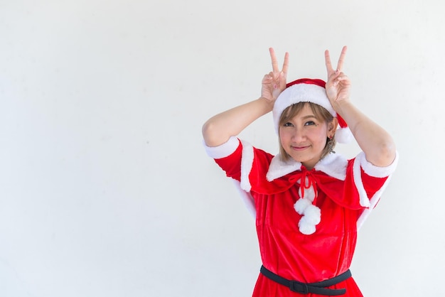 Schöne junge asiatische Frau in Weihnachtsmann-Kleidung auf weißem HintergrundThailänderGesendetes Glück für KinderFrohe WeihnachtenWillkommen im WinterHappy Woman-Konzept