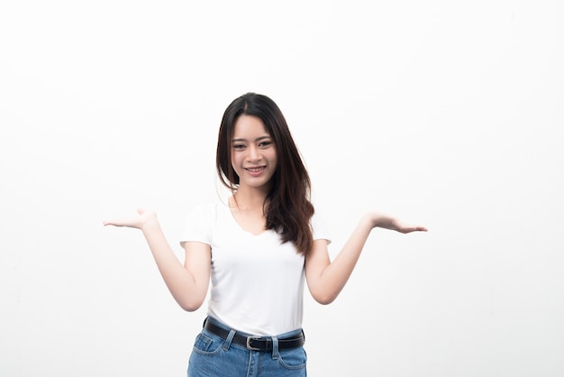 Schöne junge asiatische Frau mit Hand zeigt für Werbung isoliert auf weißem Hintergrund.