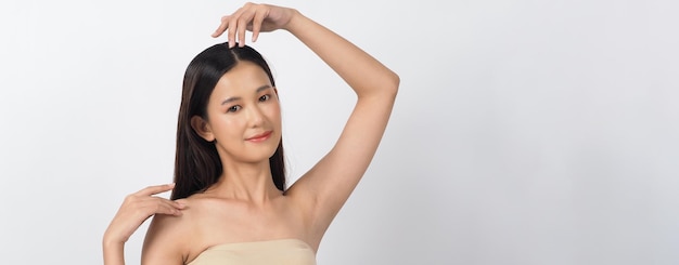 Schöne junge asiatische Frau mit sauberer frischer Haut auf weißem Hintergrund