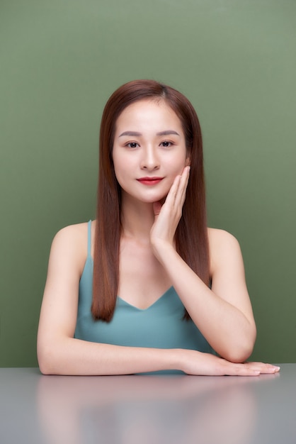 Schöne junge asiatische Frau mit sauberer frischer Haut berührt eigenes Gesicht, Gesichtsbehandlung, Kosmetik, Schönheit