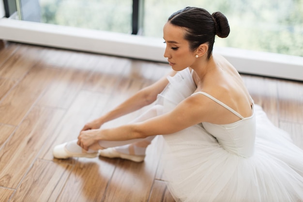 Schöne junge Balletttänzerin entspannt sich nach der Probe