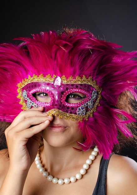 Foto schöne junge brasilianische frau mit braunen haaren, die eine venezianische maske tragen