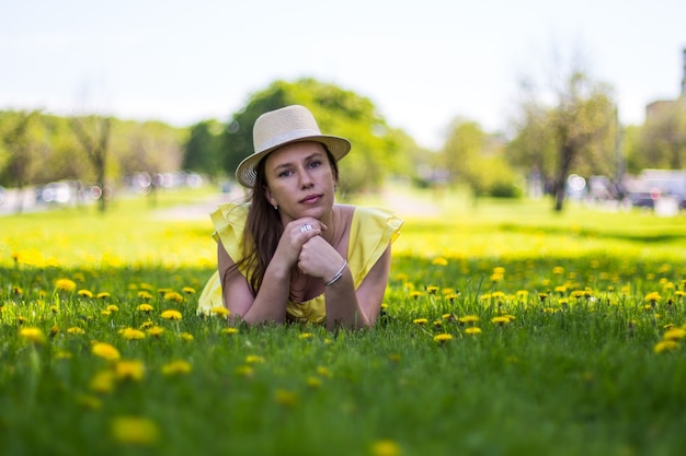 Schöne junge Dame, die im Blumenfeld liegt