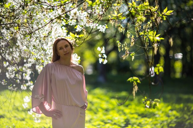 Schöne junge Dame im Garten der Kirschblüten