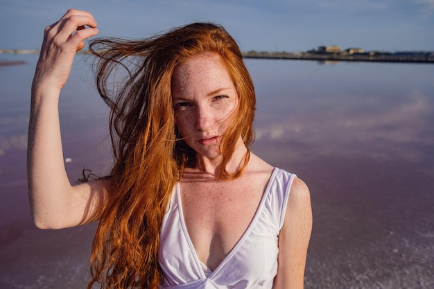 Schöne junge Dame mit langen, gesunden roten Haaren und süßem Kleid