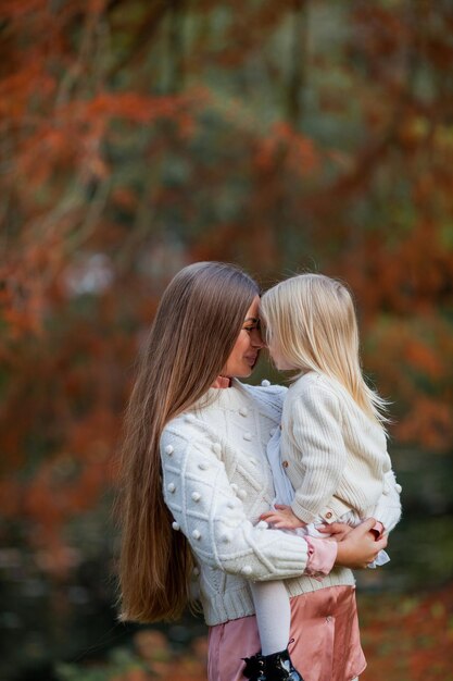 Foto schöne junge dunkelhaarige mutter spielt mit ihrer kleinen tochter 3 jahre alt im herbstpark familie herbst