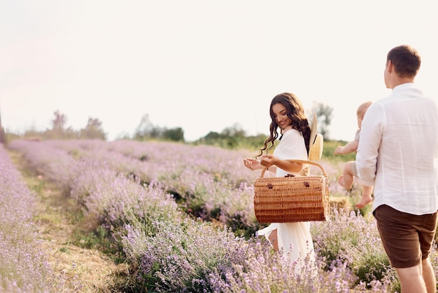 Schöne junge Familie in einem Lavendelfeld verbringt den Tag
