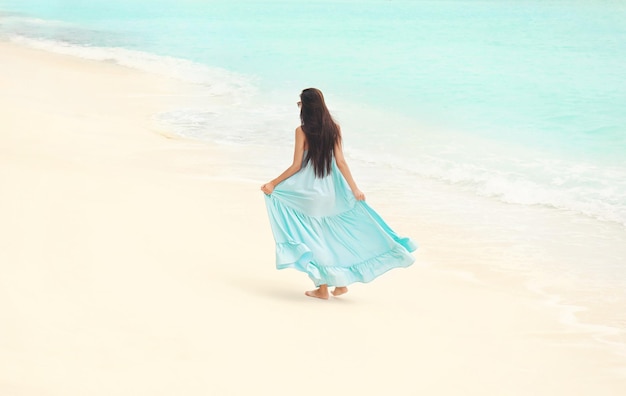 Schöne junge Frau am Meeresstrand im Resort