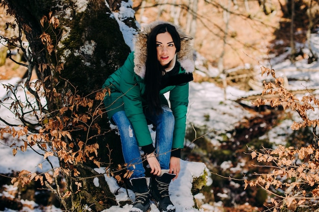 Schöne junge Frau auf einer Wanderung in einem Winterwald