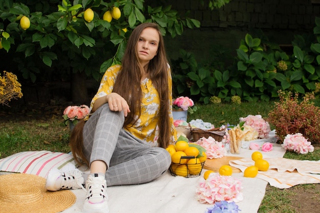 Schöne junge Frau bei einem Picknick im Garten