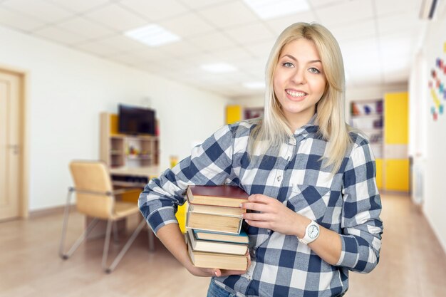 Foto schöne junge frau, die bücher hält