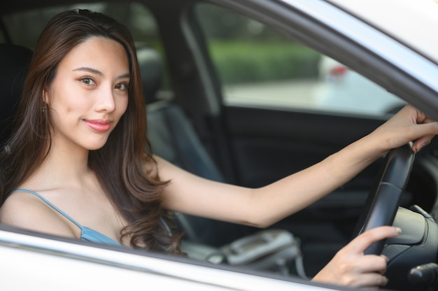 Schöne junge Frau, die ein Auto fährt