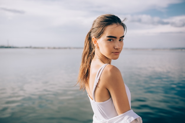 Foto schöne junge frau, die ein weißes oberteil trägt