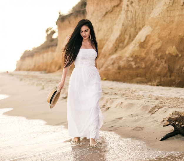 Schöne junge Frau, die einen Tag am Strand genießt