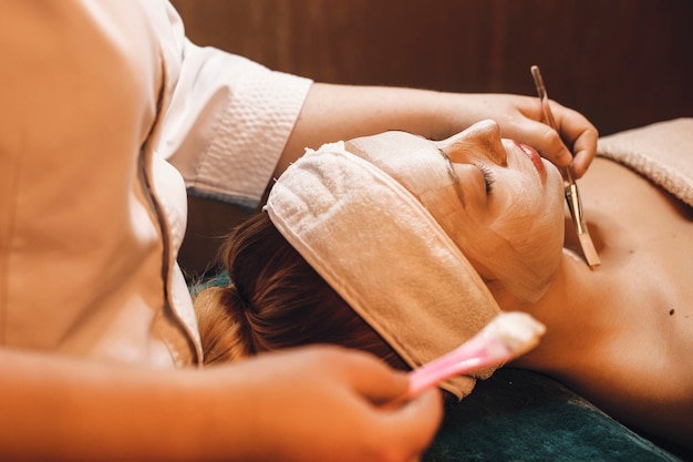 Schöne junge Frau, die Hautpflegeverfahren in einem Wellness-Spa-Zentrum hat.