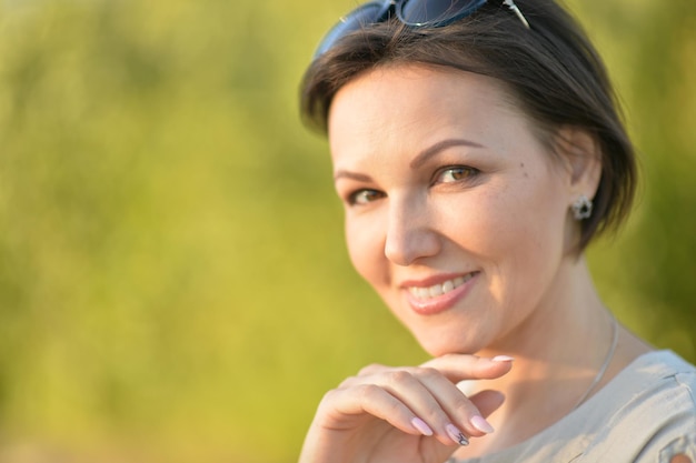 Schöne junge Frau, die im Sommerpark stillsteht