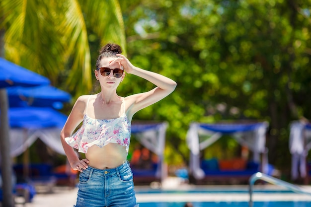 Schöne junge Frau, die im Swimmingpool sich entspannt