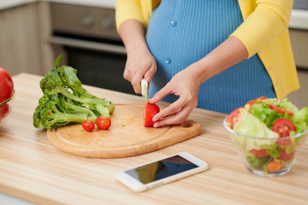 Schöne junge Frau, die in der Küche kocht