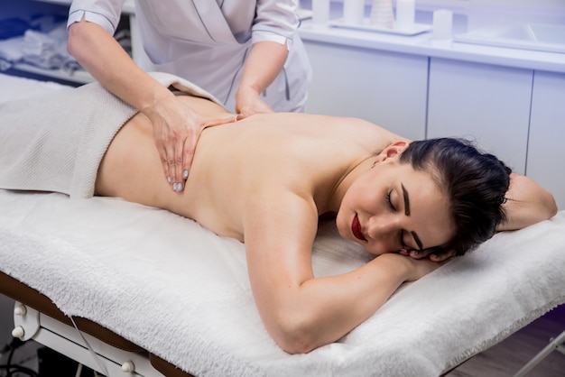 Schöne junge Frau, die Massage im Spa-Salon genießt. Kosmetologie