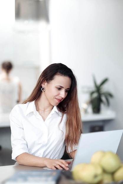 schöne junge frau, die mit laptop in der wohnkultur des coworking cafés arbeitet