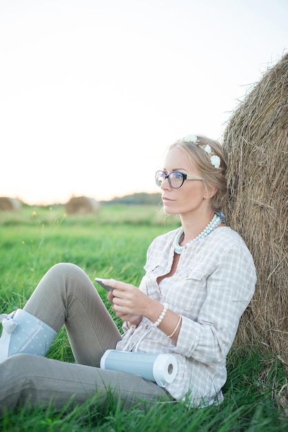 Schöne junge Frau, die Musik auf der Wiese hört