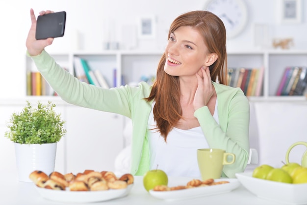 Schöne junge Frau, die selfie mit Smartphone nimmt