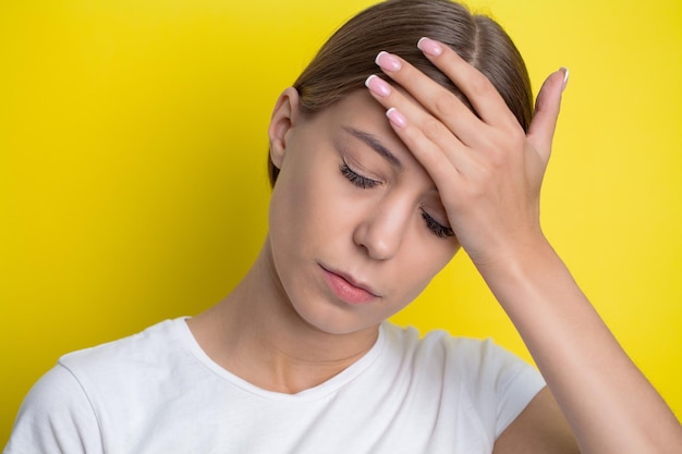 Schöne junge Frau, die starken Hauptschmerz glaubt