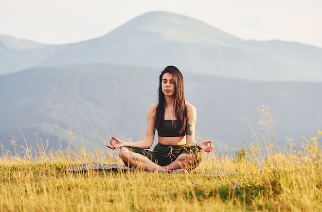 Schöne junge Frau, die Yoga-Übungen macht Majestätische Karpaten Schöne Landschaft unberührter Natur