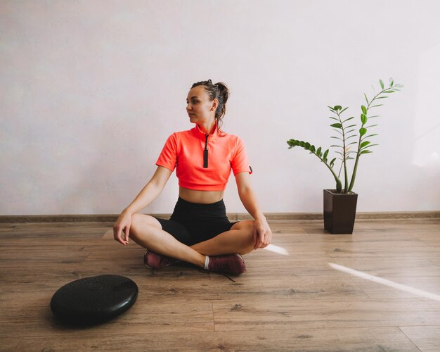 Schöne junge Frau, die zu Hause Fitness und Yoga macht