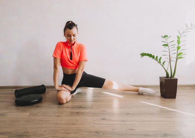 Schöne junge Frau, die zu Hause Fitness und Yoga macht