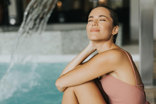 Schöne junge Frau entspannt sich am Schwimmbad