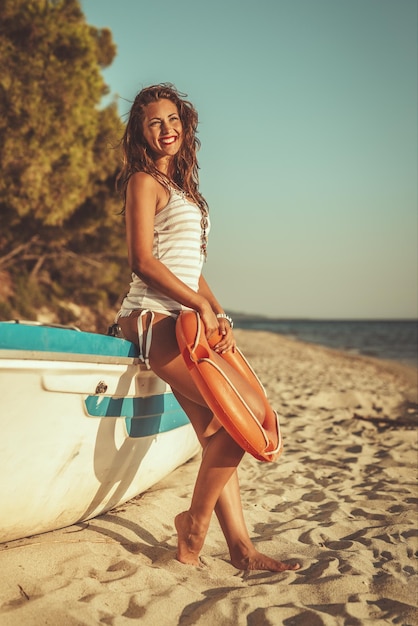 Schöne junge Frau entspannt sich am Strand. Sie steht neben Boot und Sonnenbaden.