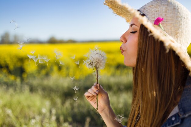 Schöne junge Frau genießen Frühling in einem Feld.