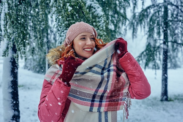 Schöne junge Frau genießt den Schnee