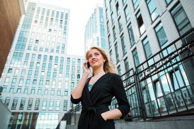 schöne junge Frau im Anzug ruft am Telefon an