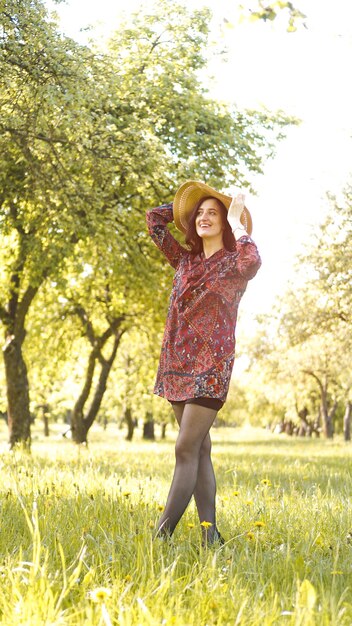 Schöne junge Frau im Freien. Natur genießen. Gesundes lächelndes Mädchen im Frühlings-Park. Sonniger Tag